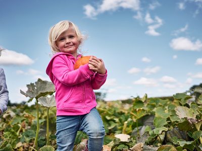 Dollinger Farm Family member holding a pumpkin.